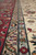 Border detail with blue-grey guard stripe, red palmette band and ivory outer flower chain