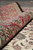 Rolled edge of the red border demonstrating dense pile depth and hand-finished selvage