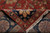 Back of the rug folded over the front, revealing knot density and cotton fringe