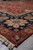 Low angle corner view of the Indian hand-knotted rug on grey stone floor