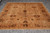 Overhead shot of the 8x10 Agra wool rug lying flat on grey tile flooring