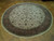 8 foot round Agra rug laid flat, ivory ground with dense floral all-over pattern