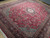 Angled view of red Tabriz area rug, dense floral vinework and deep navy main border