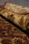 Rolled edge of the wool rug showing pile depth, red selvage and border drawing