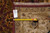 Back of the rug with dealer tag reading 7.7 x 9.4 beside a tape measure