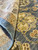Folded corner showing tight hand-knotted back, wool pile depth and gold palmette detail up close