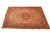 Antique wool Persian rug photographed from the side, rust medallion and ivory spandrels clearly visible