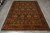 6x9 hand-knotted Indian wool rug photographed flat on grey tile, black field and burgundy border