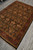 5'9" x 8'9" Indian rug seen lengthwise, black field framed by deep burgundy floral border