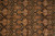 Close-up of repeating boteh medallions in camel, olive green and rust on black ground