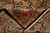 Folded corner revealing tight back weave, cotton fringe and burgundy border of the handmade rug