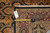 Tape measure and hand woven Oriental rug tag confirming 5'9" x 8'9" size on burgundy border
