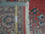 Back of the hand-knotted rug beside a ruler, showing dense wool knots per square inch