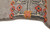 Selvage edge close-up with orange and red rosettes worked on a soft gray wool ground
