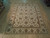 7'11" x 10' hand-knotted wool Chobi rug photographed flat on light hardwood showroom floor