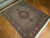 5' x 6'6" Tabriz rug angled on parquet floor showing fine Herati fish pattern detail