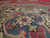 Close-up of hand-knotted wool pile with rose, teal and ivory rosette medallion motifs