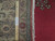 Wooden ruler scale beside ivory fringe and label reading Authentic Persian Hand Knotted Rug