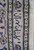 Woven signature cartouche in Persian script inside the pale guard border of this rug