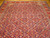 Mauve aubergine field covered in repeating Herati rosettes and lancet leaves across hand-knotted wool pile