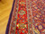 Close-up of scarlet border with palmettes, blue guard stripes and ivory meander vine detail