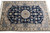 Close overhead of the central medallion, arabesque vines and ivory spandrels on this small Persian rug
