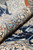 Rolled edge close-up of the light blue border showing plush wool and silk pile depth