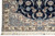 Corner detail with ivory main border, blue roundel and floral spandrel framing the navy field
