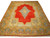 Red Persian Kerman rug on white background with gold floral border and ivory lobed central medallion