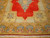 Corner view of gold spandrels, sky blue palmettes and navy cartouche border on soft wool pile