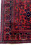 Close-up of corner showing navy border cartouches, ivory outlines and hand-knotted wool pile detail