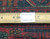 Ruler measuring the 3/8 inch wool pile beside an authentic handmade label on the rug