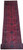 Full length view of red Khal Momadi runner rug rolled at one end, repeating diamond medallions