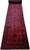 2'8" x 25'4" hand-knotted wool runner photographed rolled out, showing continuous tribal medallion pattern and serrated borders