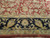Navy border detail with palmettes and pale sage guard stripes framing the red floral field