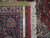 Back of this 9x12 rug with ruler showing tight hand-knotted weave and cotton foundation