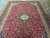 9'6" x 14' Kashan rug viewed lengthwise, crimson field framed by deep indigo blue border