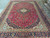 10x14 Persian Kashan rug shown full length with floral navy border and red selvage