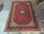 Full view of the large red and navy wool Kashan rug photographed in the warehouse