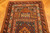 Close-up of indigo panel and ivory hooked motifs at one end of the Kazak rug