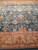 Blush palmettes and serrated leaves fill the blue-green field above the saffron gold floral border