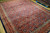 Large 9'9" x 12'10" Persian rug angled view showing navy field and tomato red borders