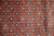 Close-up of Herati lattice with orange rosettes, teal leaves and ivory flowers on navy wool