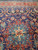 Sky blue and red central medallion set against the midnight navy hand-knotted wool field