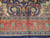 End border detail showing red palmette band, navy field vines and plain navy selvage