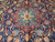 Central Sarouk style medallion in blue and red ringed by ivory serrated leaf vinery