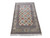 Angled full length display of ivory Persian Nain wool and silk rug on white background