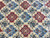 Detail of alternating burgundy and sky blue diamond medallions with palmettes on ivory ground