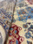 Folded pile detail revealing silk highlighted wool, burgundy medallion outline and dense hand knotted surface
