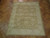 7'10" x 10'4" hand-knotted Ziegler rug lying on herringbone parquet floor in olive brown